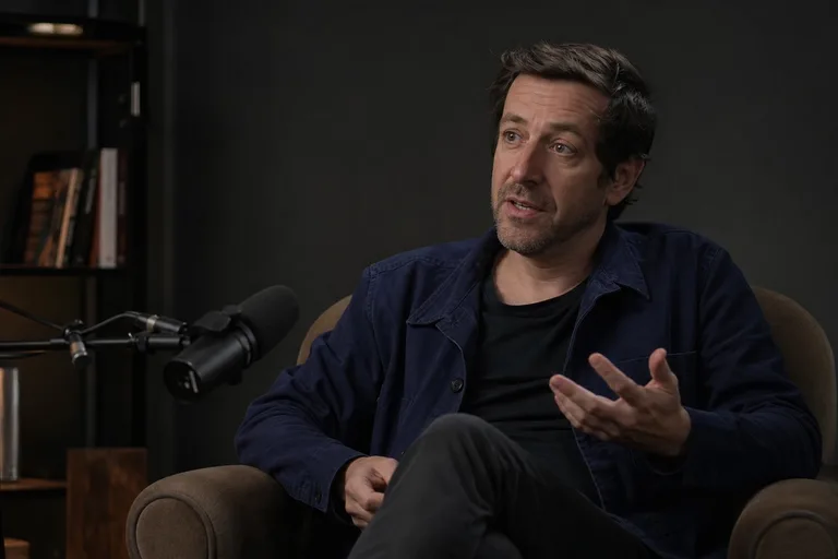 Interview vidéo artiste avec micro et fauteuil dans cadre sobre Paris