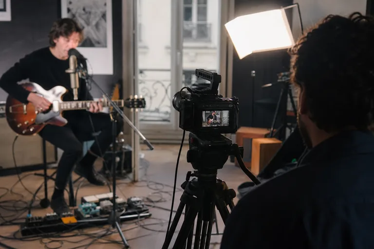 Tripod camera capturing indie artist live session in Paris