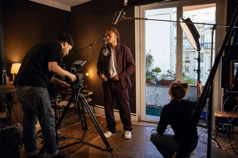 Clip or live prep: camera, microphone and lighting on set, small crew coordinating