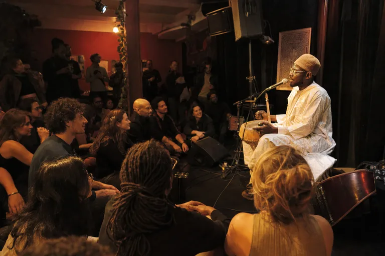 Audience and artist on stage during a nonprofit release night in Paris